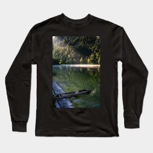 Ray of sunlight on misty lake. Wooden pier in front. Amazing shot of the Ferchensee lake in Bavaria, Germany. Scenic foggy morning scenery at sunrise. Long Sleeve T-Shirt